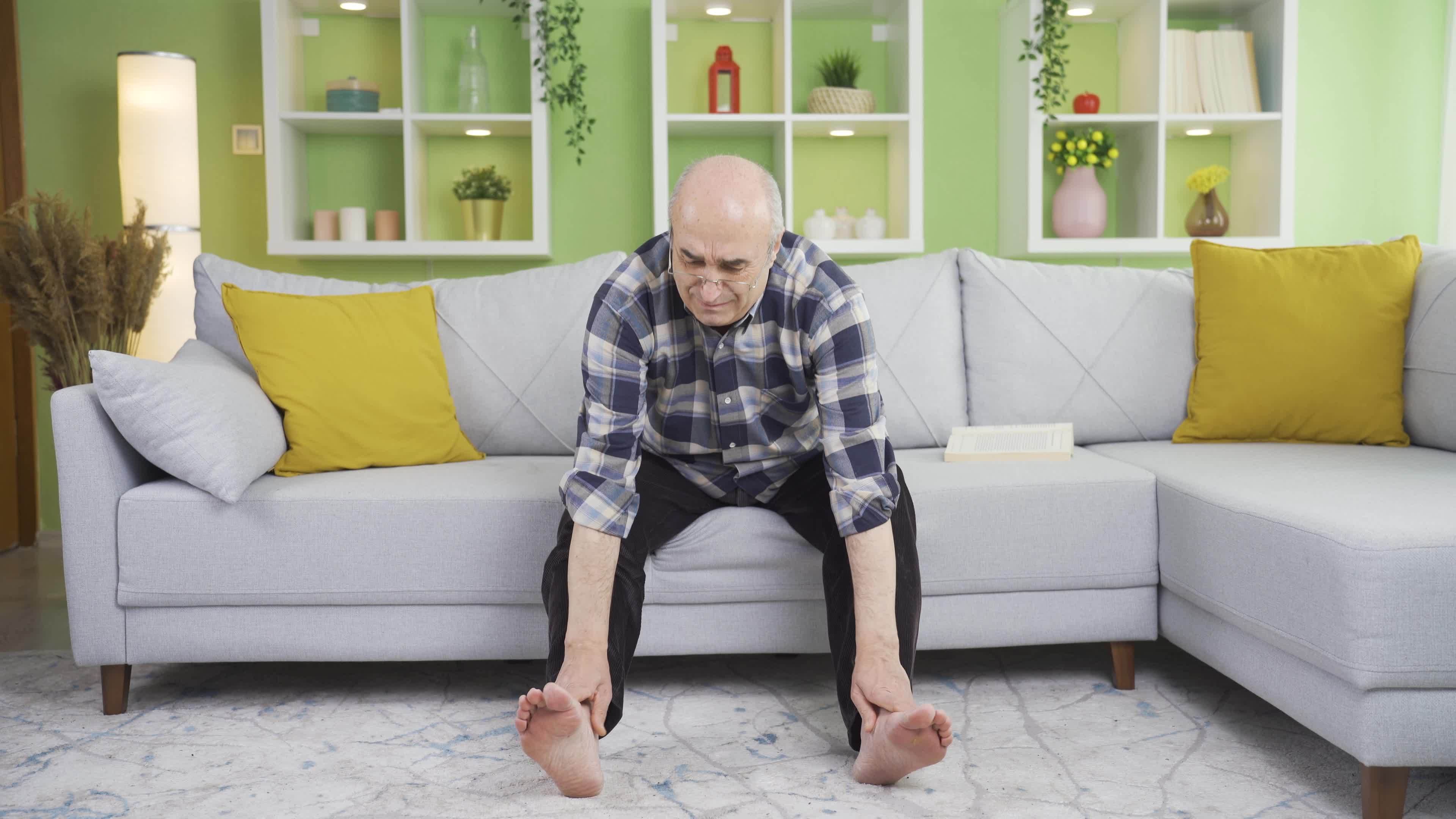 Old man scratching his feet violently and intensely. Annoyed old man