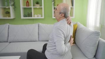 Old man with back pain. Weak and weak bones and joints. Old man with sore back and waist doing self-massage, stretching his body. Bone and skeleton. video