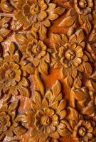 Pattern of flower carved on wood background. Traditional Thai style pattern photo