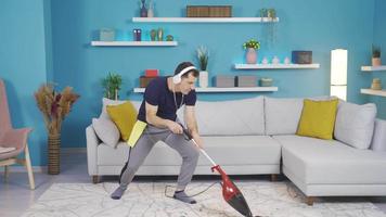 le homme qui nettoie le sien maison obtient immergé dans la musique et soudainement imagine lui-même comme une chanteur avec une balai dans le sien main. video