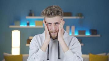 Portrait of nervous and stressed young man.  Thoughtful and nervous young man in front of camera at home feels anxiety and panic. video