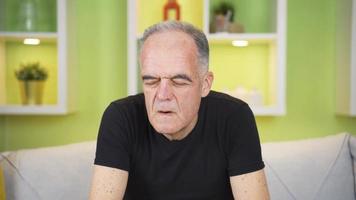 sudorazione problema. febbre e sudorazione. sudorazione vecchio uomo dà aria per il suo viso con il suo mani. il sudato vecchio uomo. video