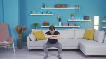 A man trying to do sports, no news of what to do. The middle-aged inexperienced man is trying to exercise at home, unsure of what to do. video