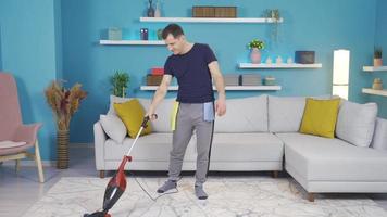 The man who cleans his house alone, laughing, having fun, talking to himself. The happy man is in good spirits, laughing and having fun cleaning, talking to himself and smiling. video