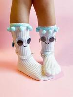 Baby socks with eyes and smile on pink background photo