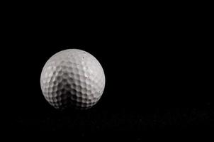 Golf ball isolated on black background photo