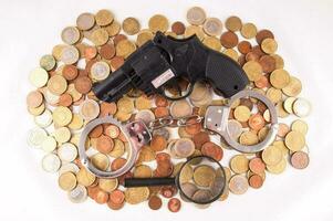 Gun, handcuffs, loupe and coins photo