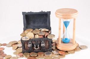 Wooden chest, hourglass and coins photo