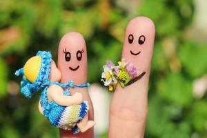 dedo Arte de un contento familia participación un pequeño niño. concepto de marido dando flores a su esposa para nacimiento de niño. foto