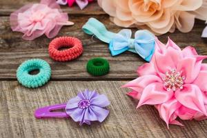 Different hair clips on wooden background photo