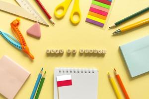 Back to school background. School accessories on a yellow background. Wooden blocks with letters photo