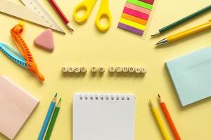 Back to school background. School accessories on a yellow background. Wooden blocks with letters photo