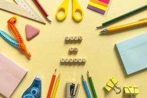 Back to school background. School accessories on a yellow background. Wooden blocks with letters photo