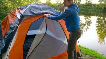 donna è mettendo un' turista tenda nel il foresta video