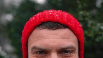 portret van een Mens in een rood pet in besneeuwd weer buitenshuis video