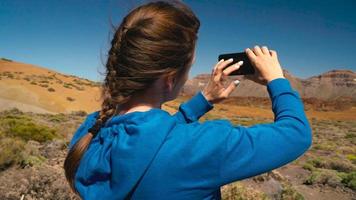 activo caminante mujer excursionismo en teide nacional parque y hace foto paisajes en el teléfono inteligente tenerife, canario islas video