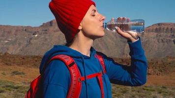 escursioni a piedi donna potabile acqua dopo escursione su teide, tenerife. caucasico femmina turista su tenerife, canarino isole video