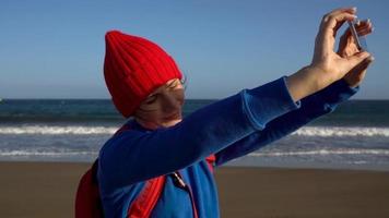 aktiva vandrare kvinna promenader på de strand till de vatten. caucasian ung kvinna med ryggsäck på teneriffa, kanariefågel öar video