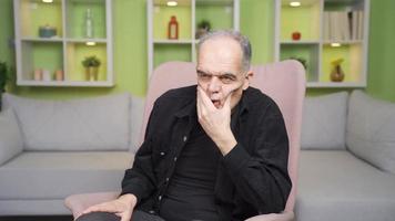 nerveux vieux homme frottement le sien stressé affronter. personnes âgées homme frottement le sien visage stressé. video