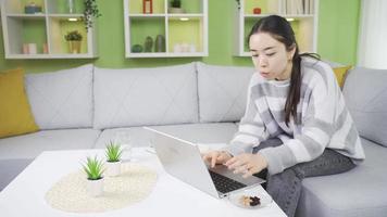 asiático joven mujer comiendo nueces a consumir suficiente proteína. asiático joven mujer come nueces a hogar, quiere proteína y sano viviendo. video