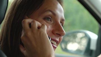 Frau spricht auf das Smartphone im das Auto video