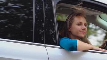 Two young women ride in a car and have fun. Slow motion video