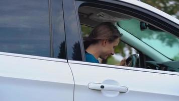 Two young women ride in a car and have fun. Slow motion video