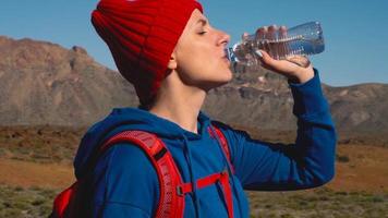 Hiking woman drinking water after hike on Teide, Tenerife. Caucasian female tourist on Tenerife, Canary Islands video