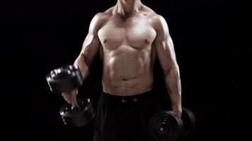 hombre es haciendo ejercicios con un barra con pesas, formación en un negro antecedentes en el estudio video