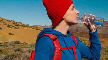 caminhada mulher bebendo água depois de caminhar em teide, tenerife. caucasiano fêmea turista em tenerife, canário ilhas video