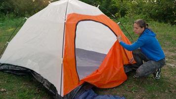 femme est en mettant une touristique tente dans le forêt video