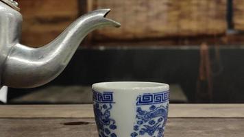 Footage of a teapot pouring hot tea into the glass causing white steam. video