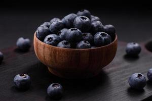 Delicious fresh blueberries on a textural black concrete background photo