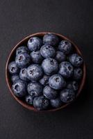 Delicious fresh blueberries on a textural black concrete background photo
