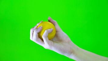 Hand holding a stress ball with green screen video