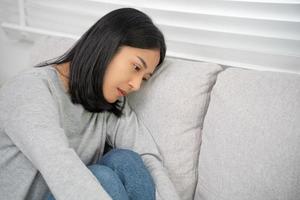 Depression and mental illness. Asian woman disappointed, sad after receiving bad news. Stressed girl confused with unhappy problems, arguing with boyfriend, cry and worry about unexpected pregnancy. photo