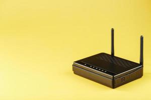 Wi-Fi router in black on a yellow background with free space. photo