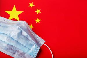 Medical mask on the background of the Chinese flag. Disposable face masks for viruses, Coro novirus. photo