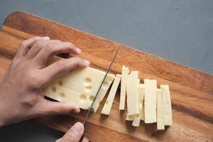 Top view of cutting cheese on chopping board photo