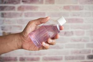 hand hold a mouthwash liquid container photo