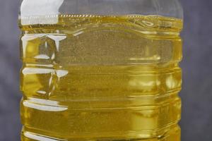 botella de aceite de girasol amarillo en la mesa foto