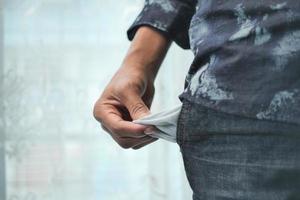 young man shows empty pant pocket with copy space photo