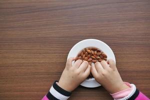 child hand pick almond nuts photo