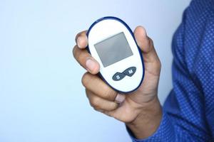 man's hand measuring blood sugar level photo