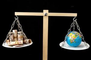 Scale with money and earth globe. photo