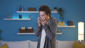 Young man having a nervous breakdown at home alone. Young man is freaking out with anger standing on the collar in the living room. video