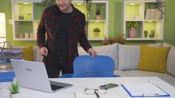 Happy and dancing man coming to his desk and getting to work. The middle-aged man comes to his home office and starts working energetically, happily, dancing. video