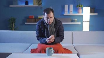 The man who is cold at home. Natural gas outage. The man wearing his coat is cold at home. video