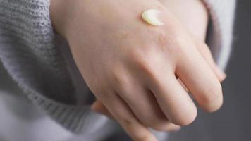 A woman with redness and allergies on her hands applies cream. Close-up woman applying cream on her hands, she has allergies, ringworm, rash, bacteria. video