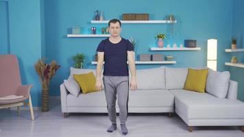 Man warming up, stretching at home. Mature man squatting and doing stretching exercises at home. video